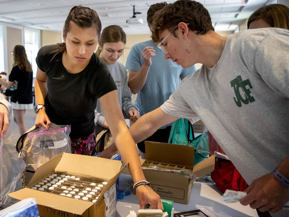 Students pack backpacks for donation