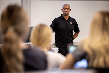 A lecturer listens to a student asking him a question.