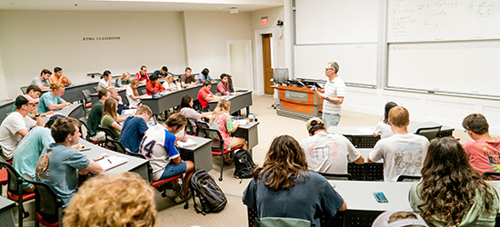 A professor leads a full class of students