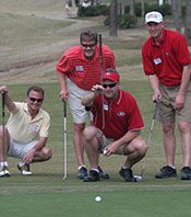 Four people knee on a golf course