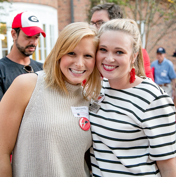 Two high school students smiling while visiting Terry.
