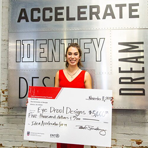 Kendra holds her check for 5 grand as part of the accelerate program