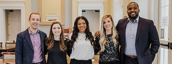 Five Terry students in professional attire stand together and smile