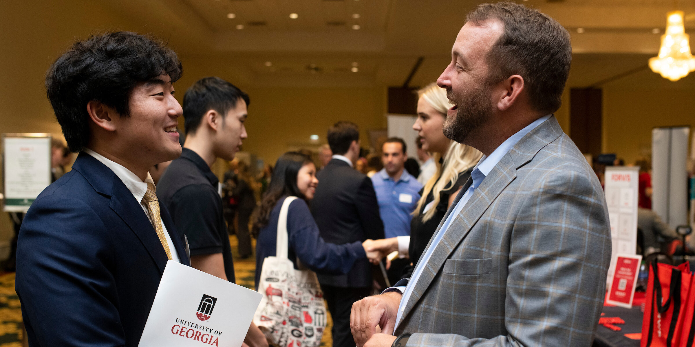 A student and a professional chatting with each other at the Tull Career Fair