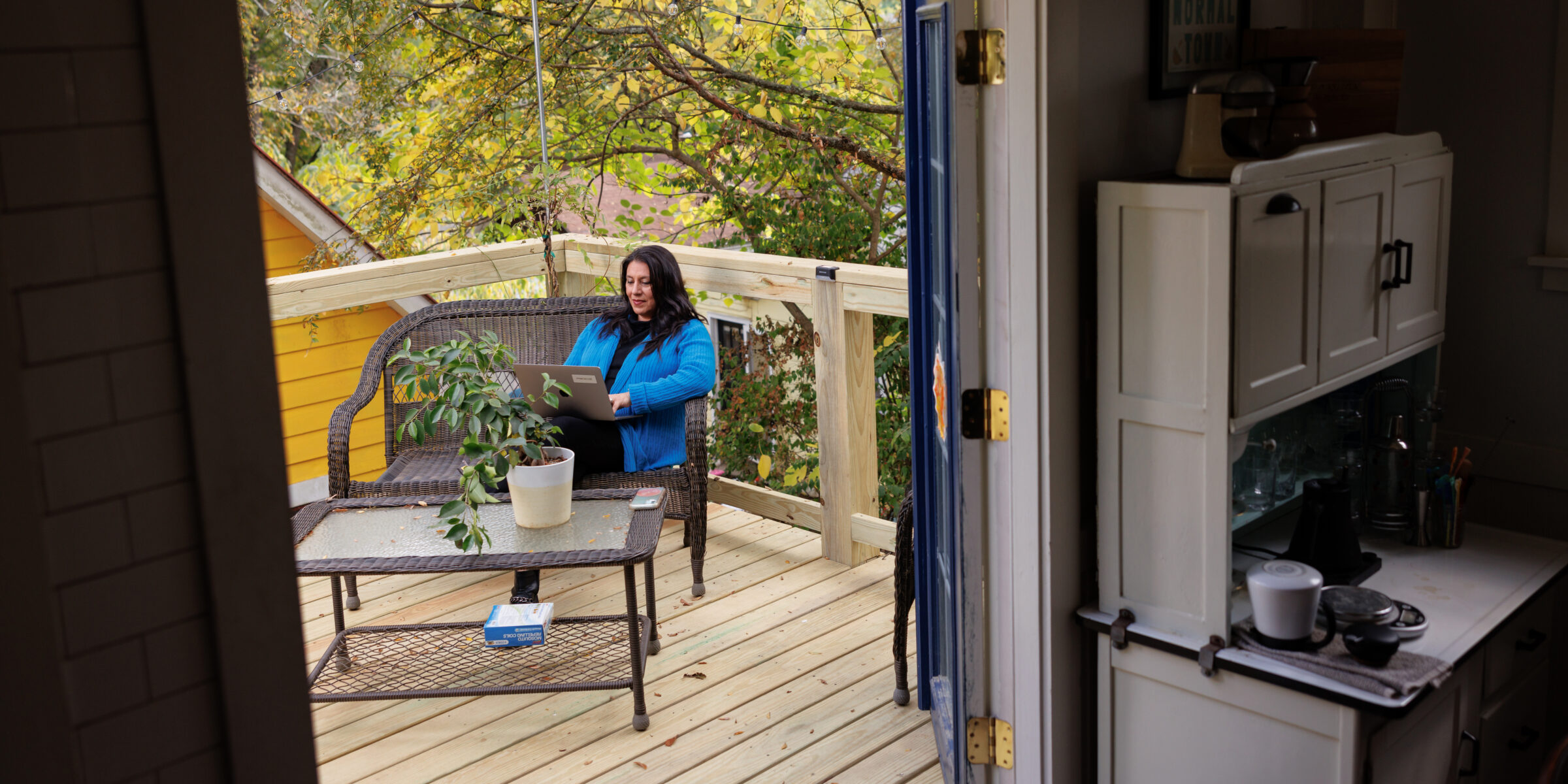 A student studies with her computer on her outdoor deck at home.