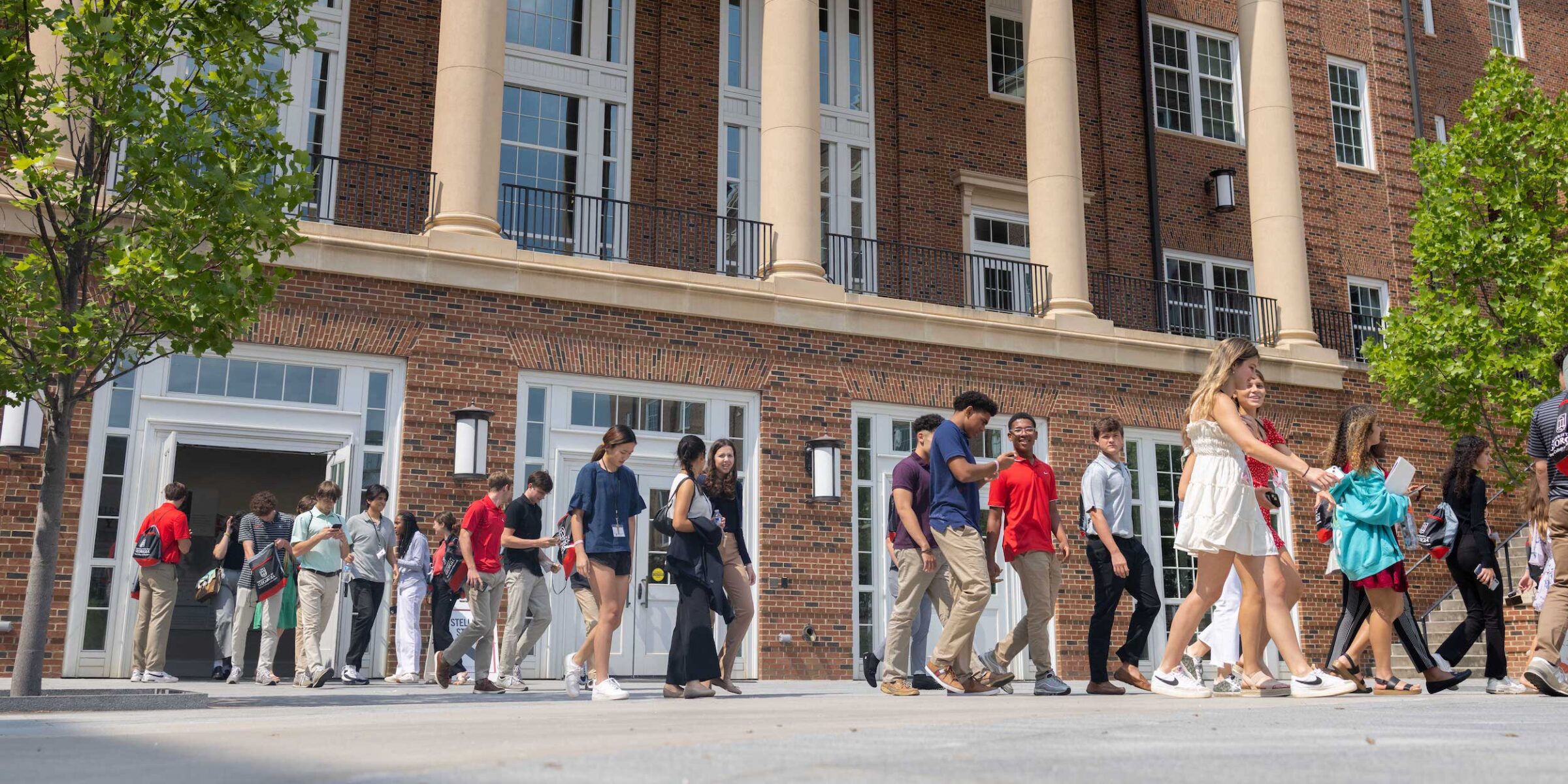 Students walk out of Amos Hall as a group.