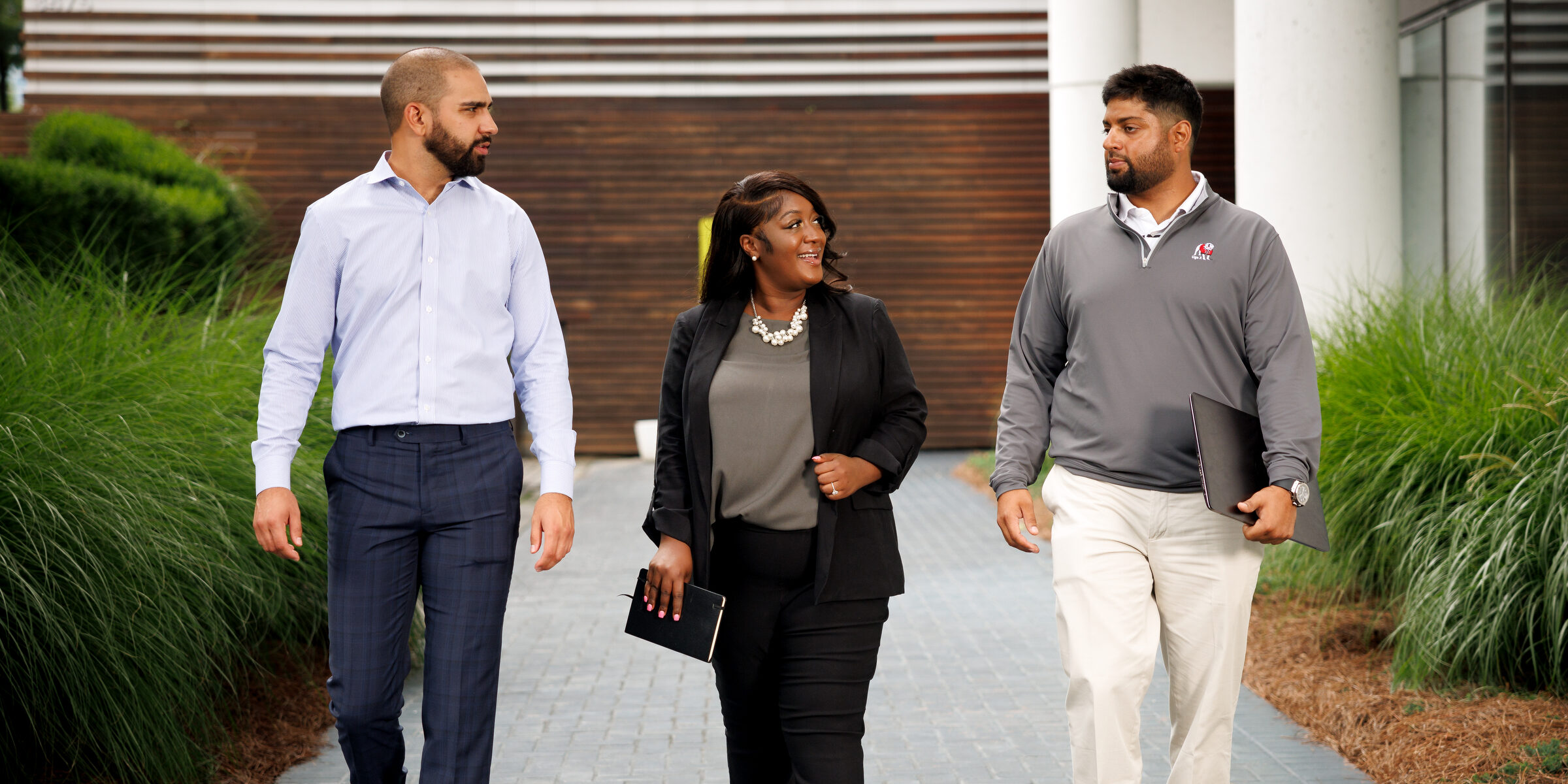 Three people walking outside and chatting