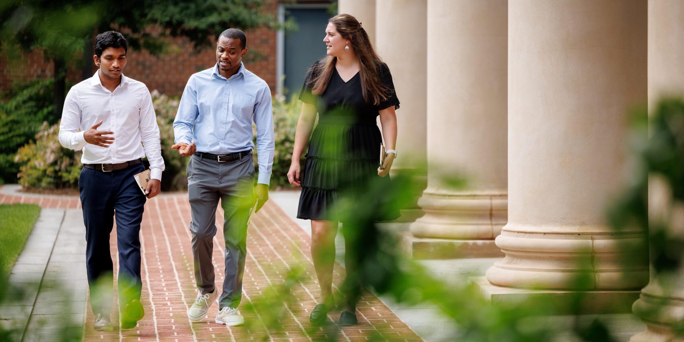 Three people chatting and walking outside