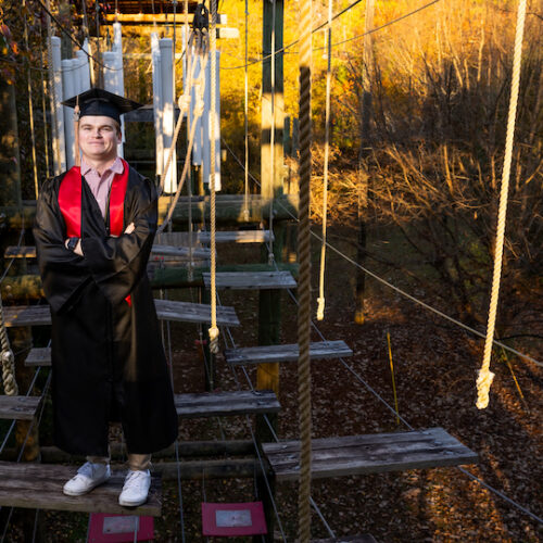 Accounting graduate Kyle Huemme stands on a rope bridge at the UGA ropes course.