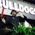 graduate celebrates on stage at convocation ceremony
