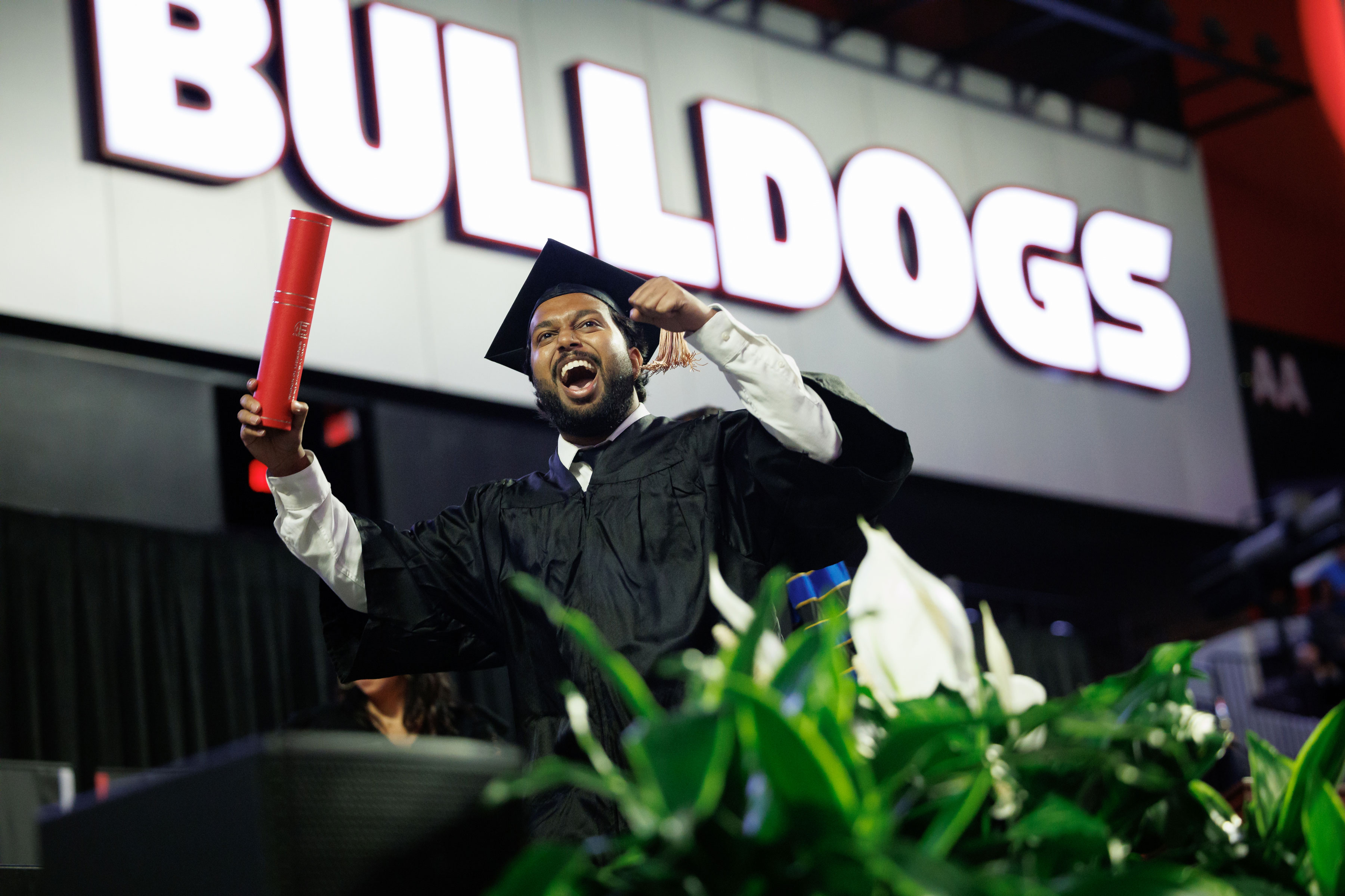 graduate celebrates on stage at convocation ceremony