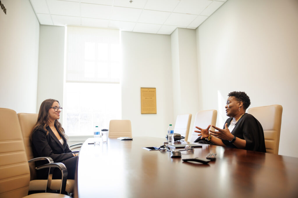 Two professional women speaking to each other in a conference room