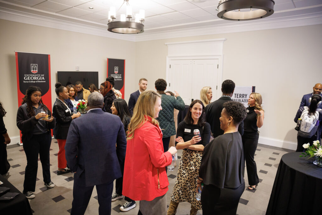 A group of people in a professional setting chatting with each other