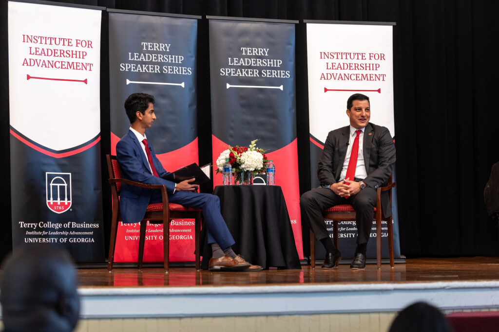 Paul Shoukry sits on the UGA Chapel Stage in front of ILA banners