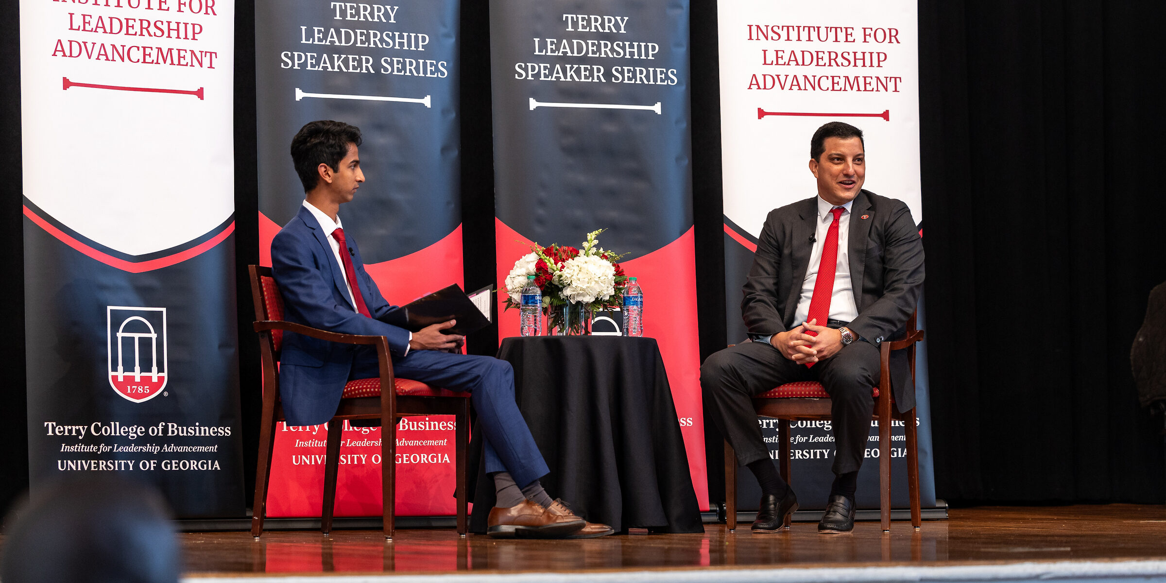 Paul Shoukry sits on the UGA Chapel Stage in front of ILA banners