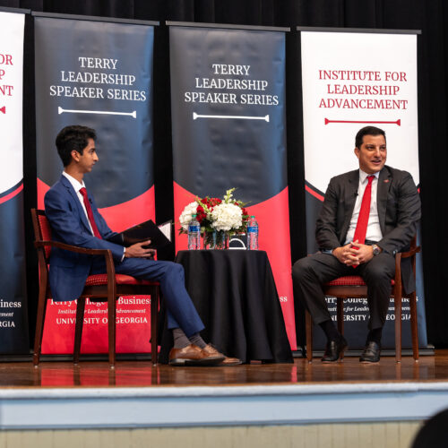 Paul Shoukry sits on the UGA Chapel Stage in front of ILA banners