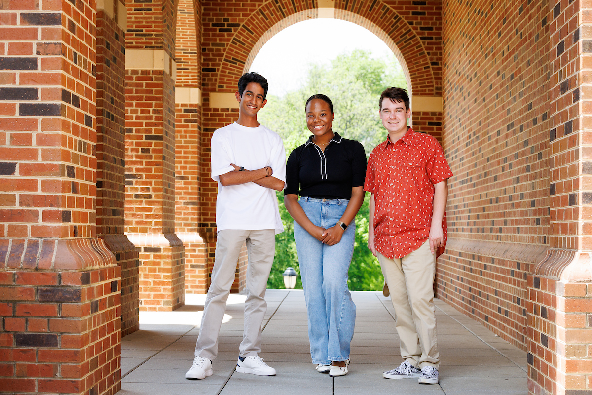 uhusuru Ranasinghe left, Anthony Tringali, right, and Lauryn Sanders, center, pose for a portrait in under and artchway in the UGA Business Learning Community.