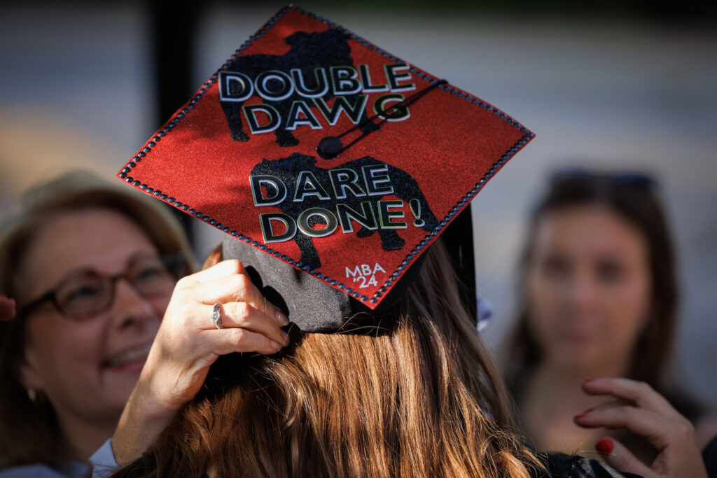 close up of female wearing graduation cap reading "Double Dawg Dare Done!"