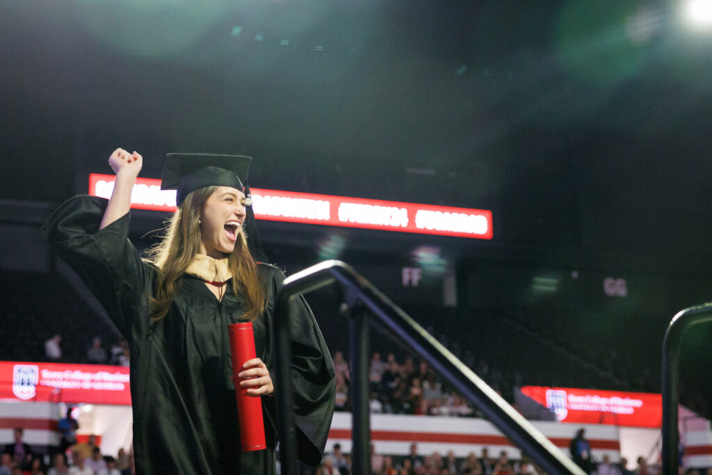 female graduate celebrating on stage after being recognized