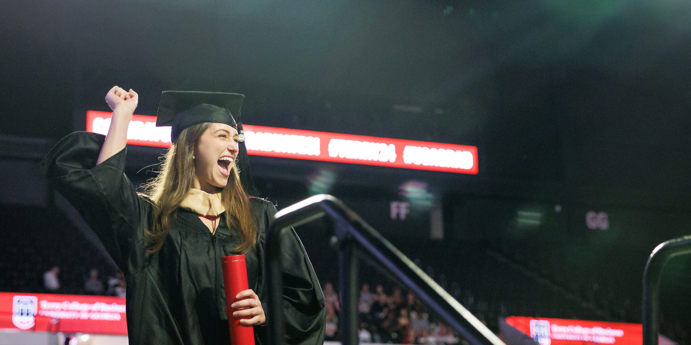 female graduate celebrating on stage after being recognized