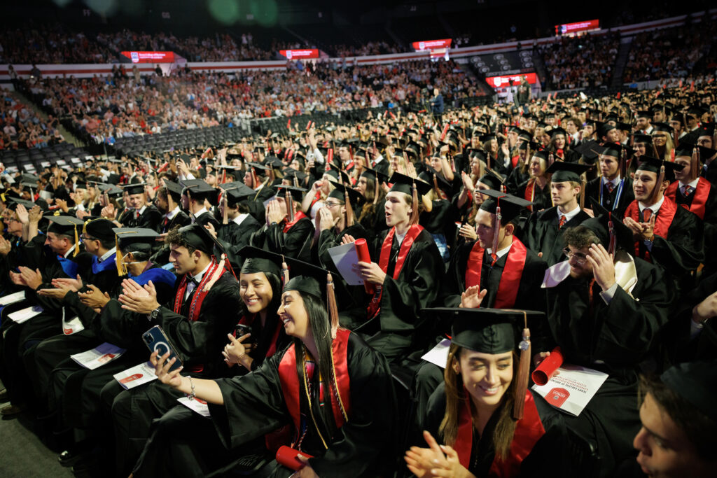 hundreds of graduates cheering from their seats