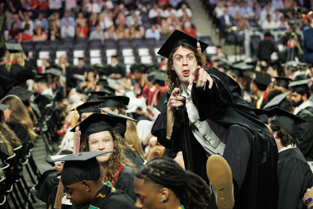 graduate humorously poses for camera