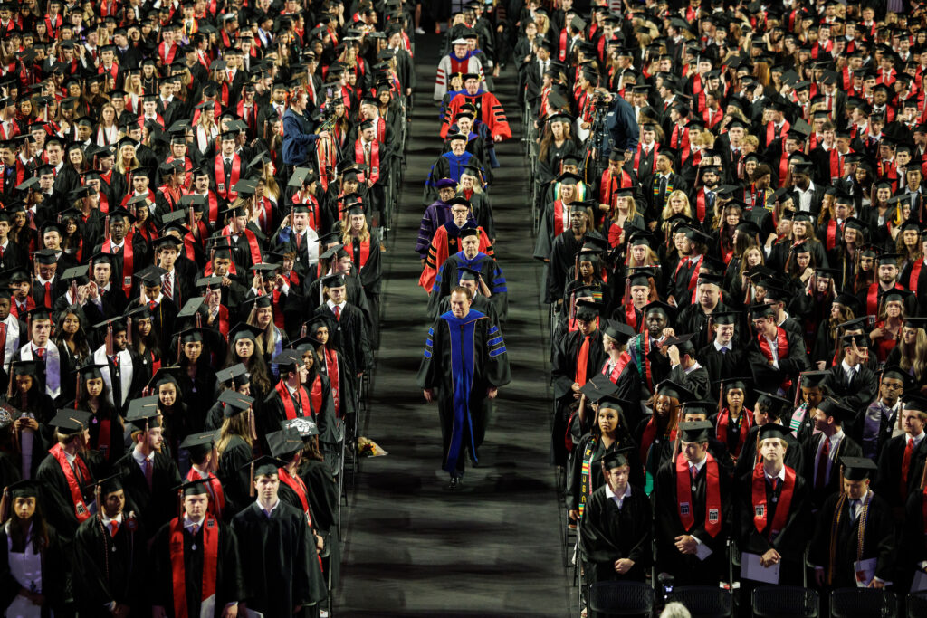 faculty and administration walking down aisle between graduates at convocation
