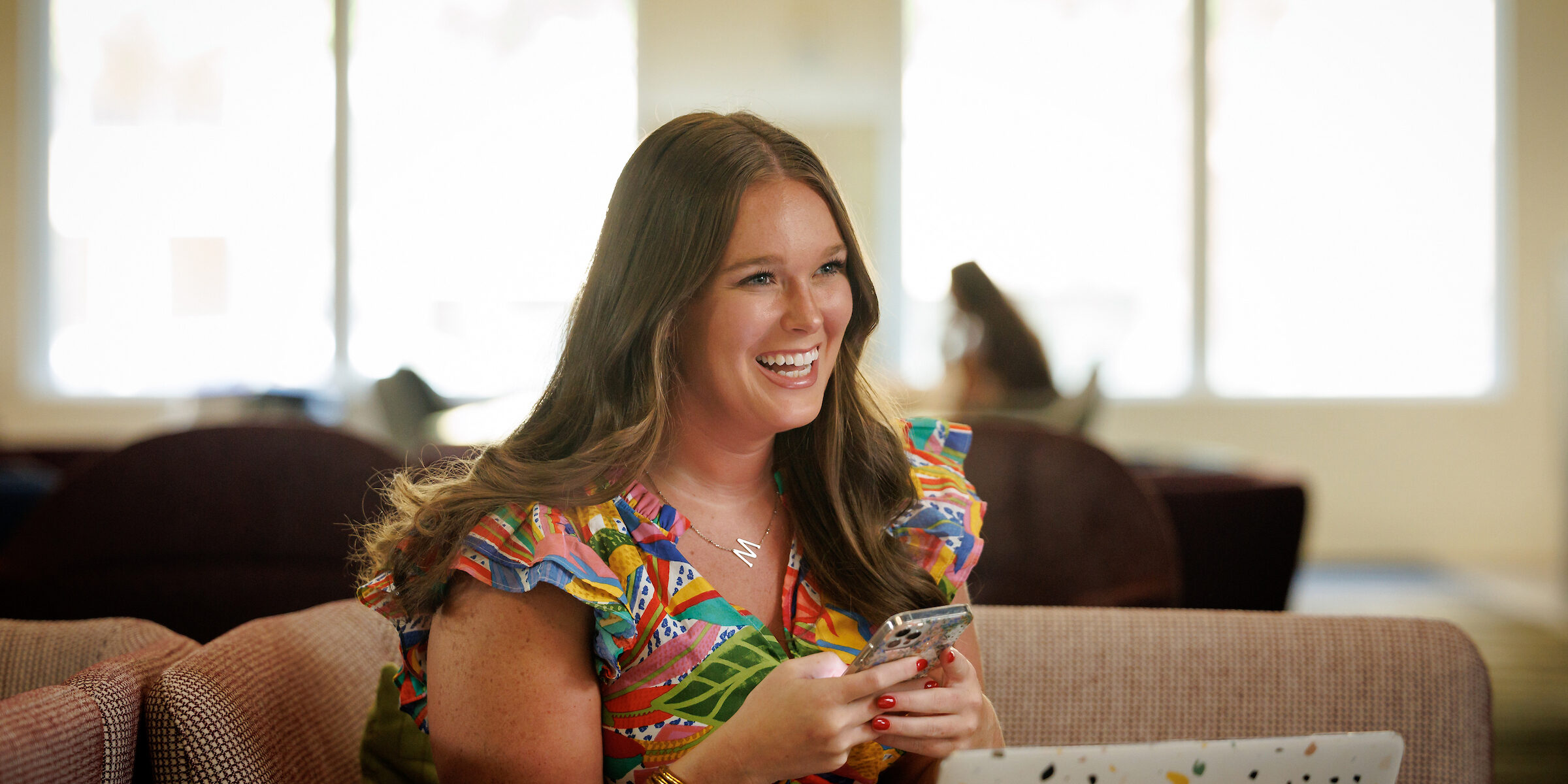 Smiling woman sitting with phone in hand