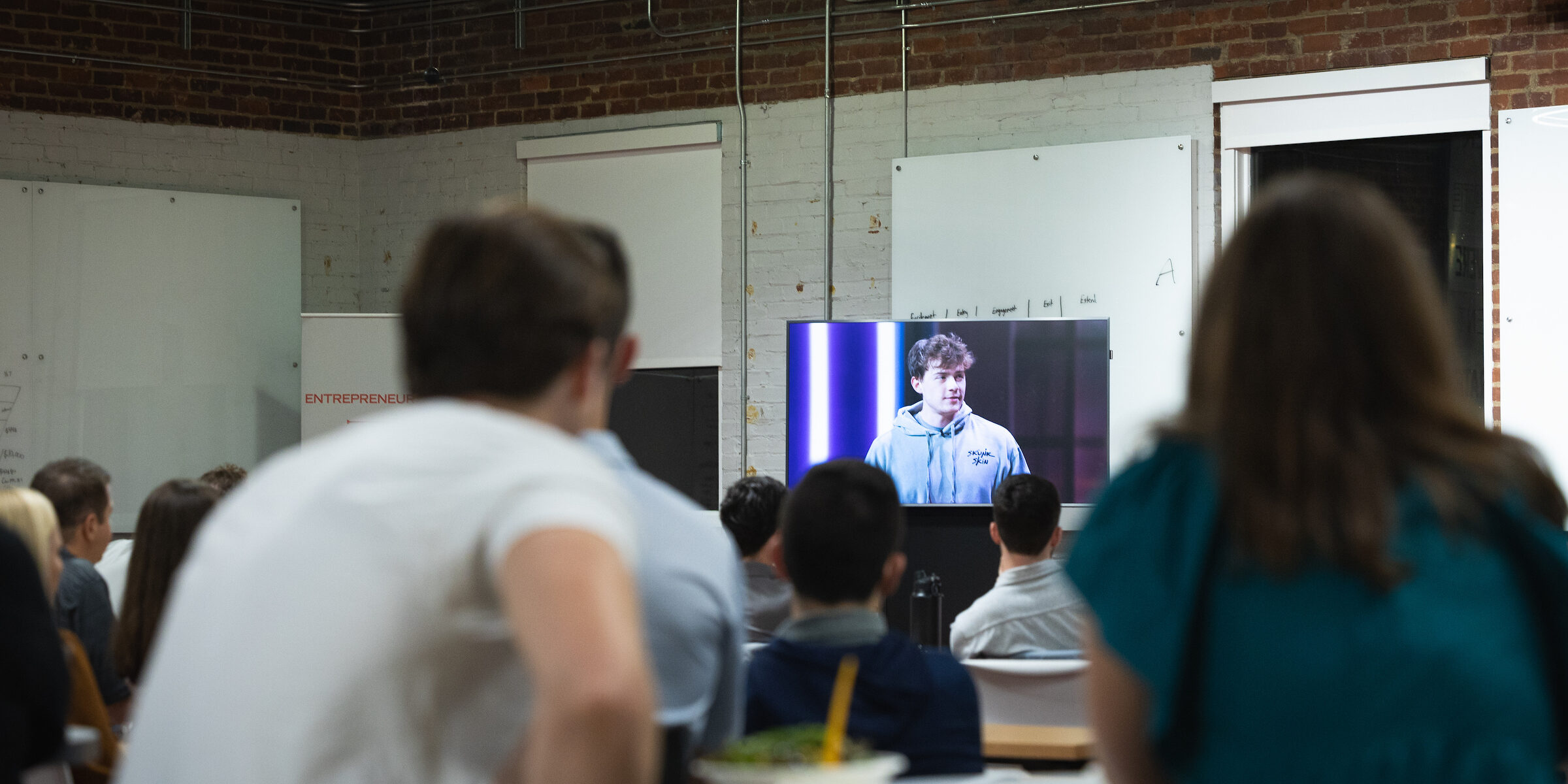 A crowd watches UGA alum Matt Tesvich on TV at his watch party for the premier of the show "Buy it Now!"