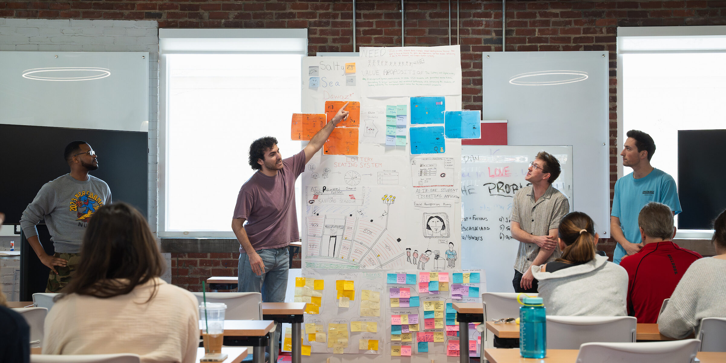Students present in front an Entrepreneurship Class in UGA's Studio 225. New UGA Entrepreneurship faculty