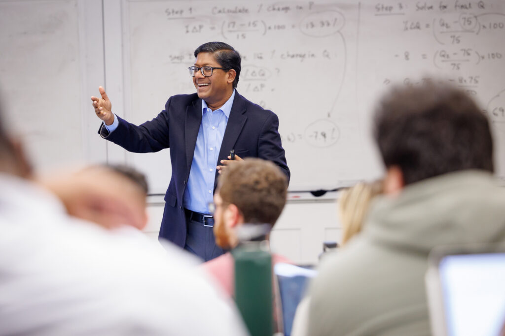 A professor, Dr. Santanu Chatterjee, happily giving a lecture to an engaged audience