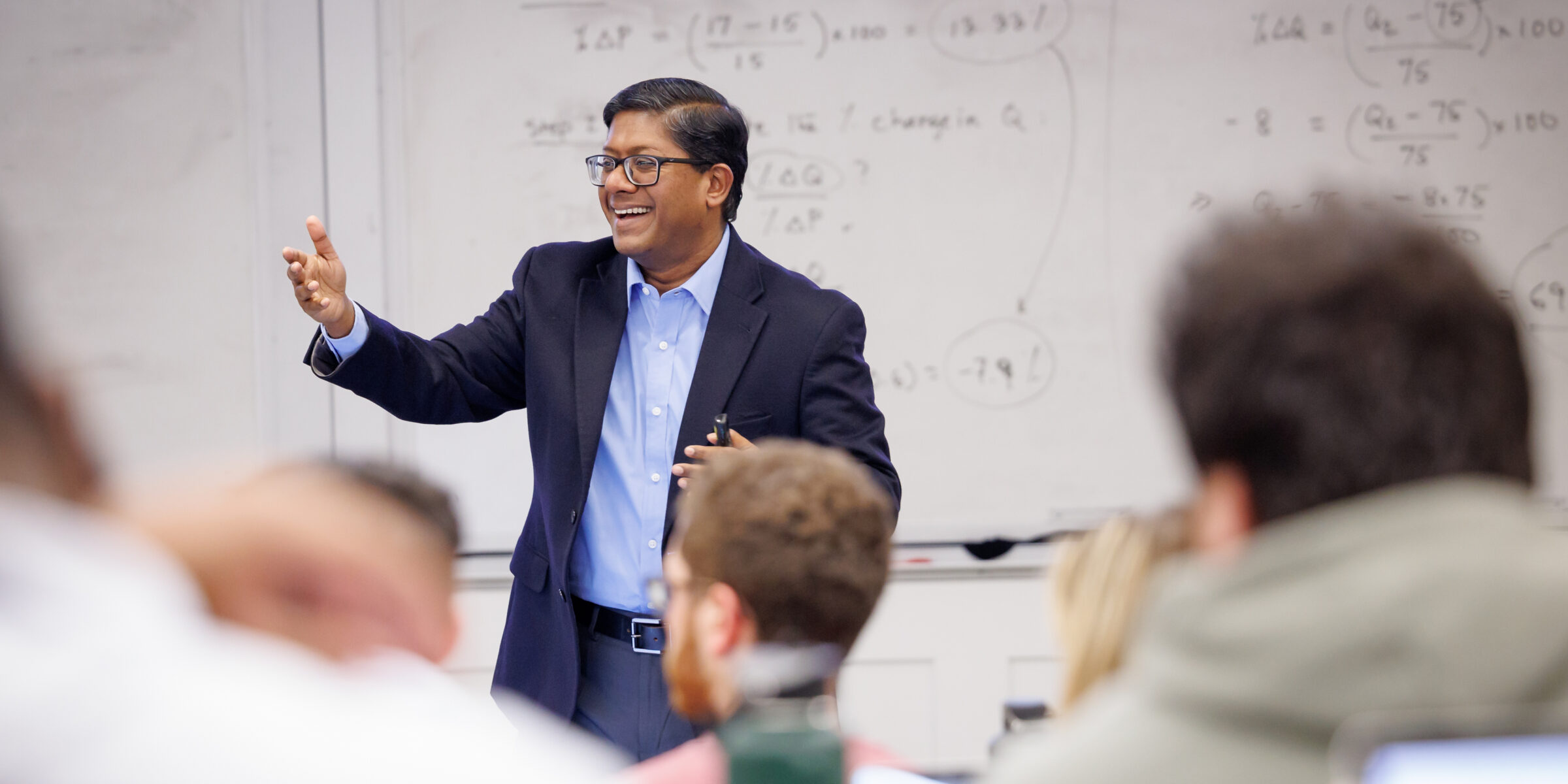 A professor, Dr. Santanu Chatterjee, happily giving a lecture to an engaged audience
