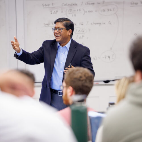 A professor, Dr. Santanu Chatterjee, happily giving a lecture to an engaged audience