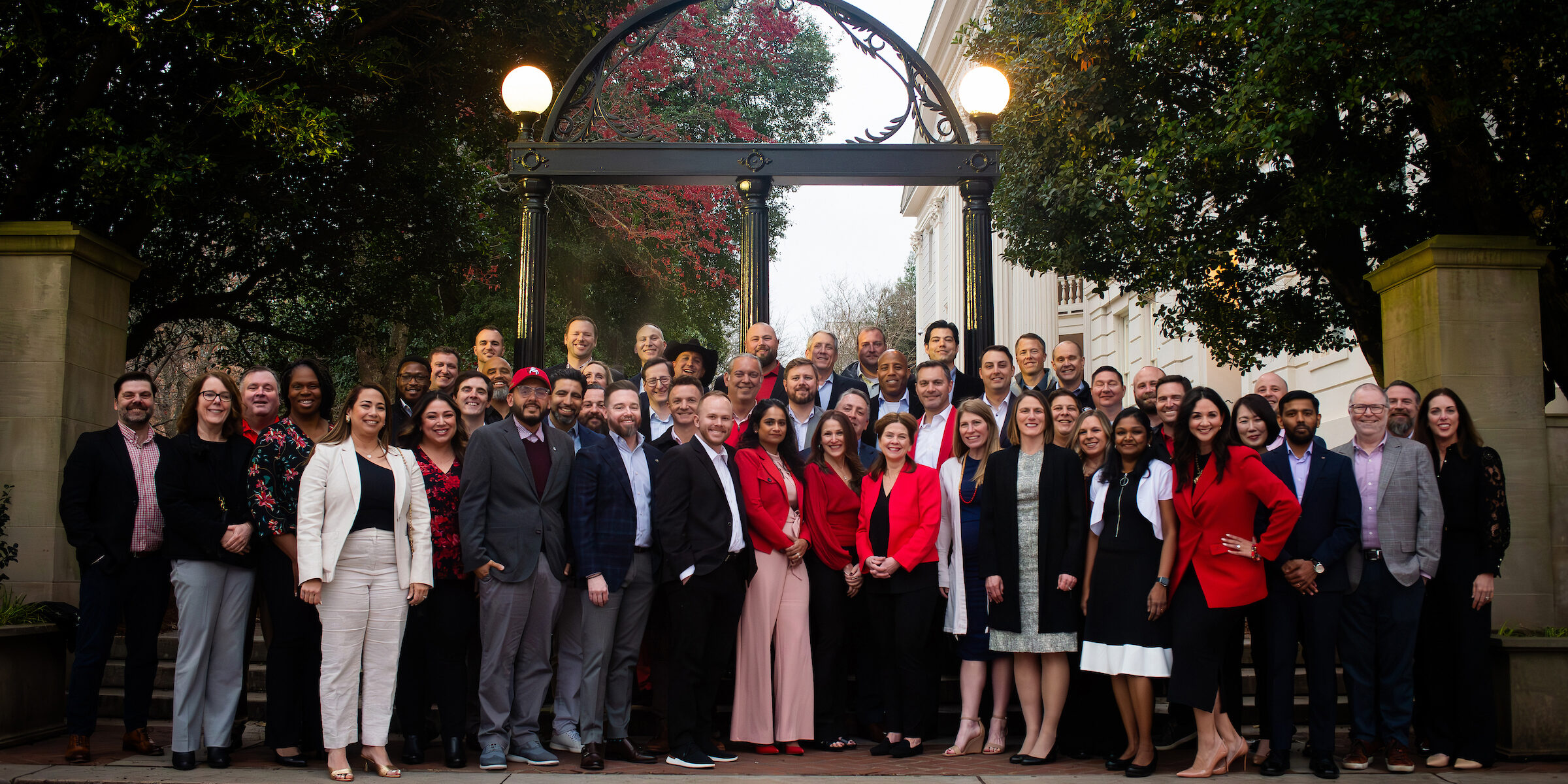 A large group photo in front of the UGA arch