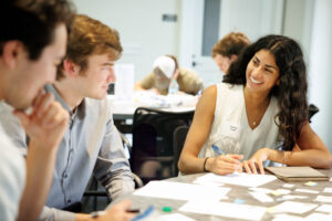 Two men and woman discussing something cheerfully at a table