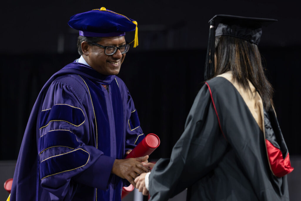 2026.05.07_rh_Grad_Convocation_025 Dean Santanu Chatterjee greets graduates during the UGA Terry College of Business graduate convocation ceremony at Stegeman Coliseum.