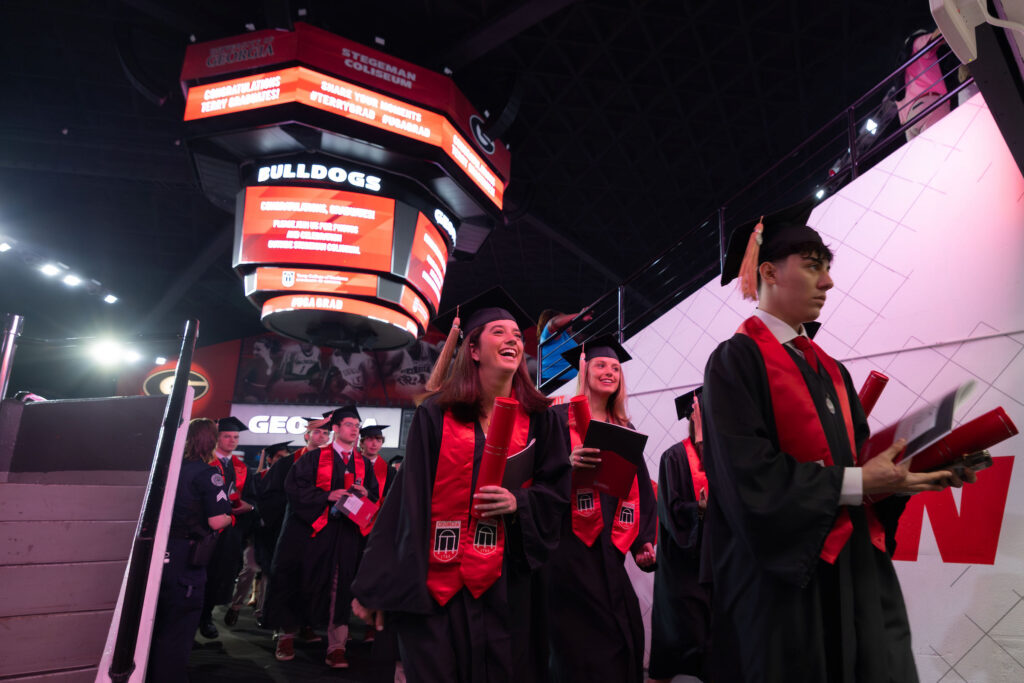 2026.05.08_rh_Undergrad_Convocation_022 A crowd of graduates exit the floor of Stegeman Coliseum after Terry College Undergraduate Convocation on May 8.