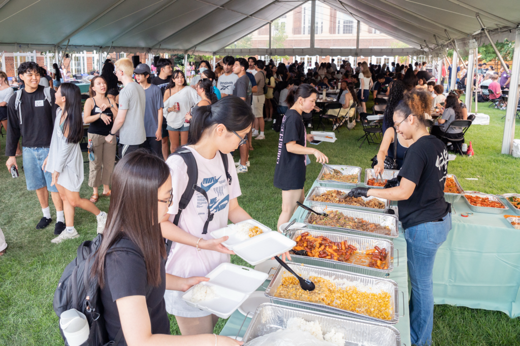 Students go down a buffet line of foods from different cultures at Terry College Welcome Back Block Party