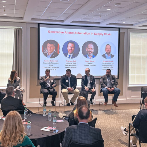 Faculty and industry sit at the front of a crowded room as part of the Terry College's Supply Chain Advisory Board fall meeting to discuss the future of AI and supply chain management