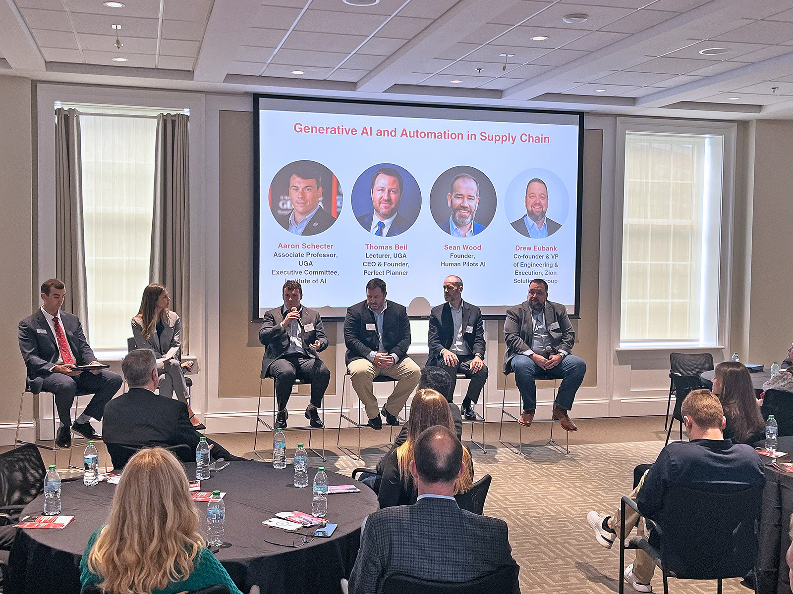 Faculty and industry sit at the front of a crowded room as part of the Terry College's Supply Chain Advisory Board fall meeting to discuss the future of AI and supply chain management