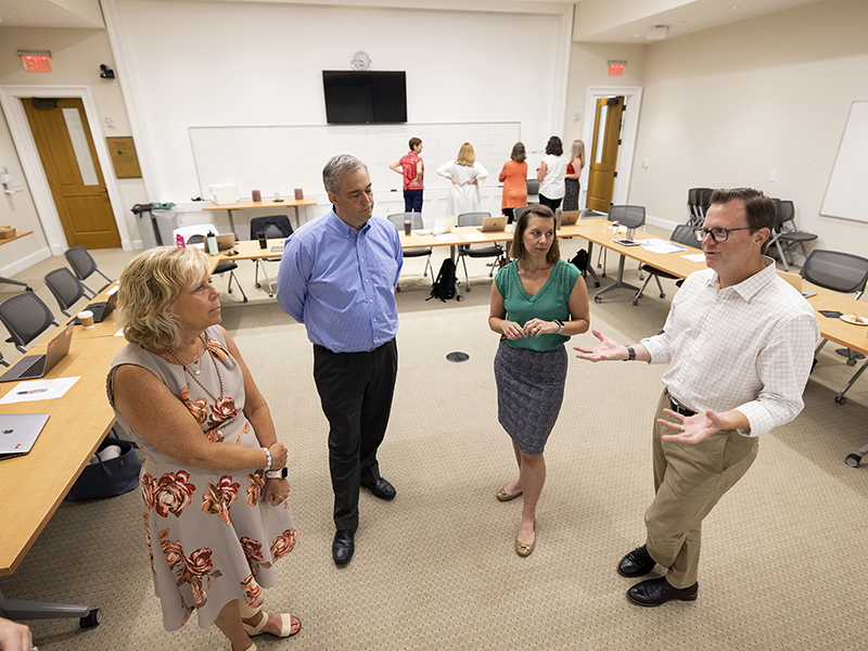 Faculty stand in a room discussing active learning