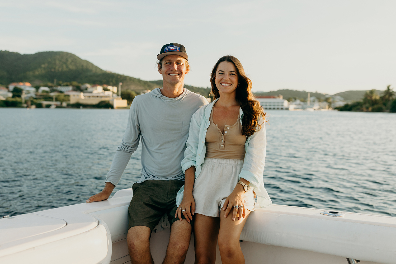 A couple enjoying a serene boat ride on the vast ocean, surrounded by calm waters and a clear blue sky