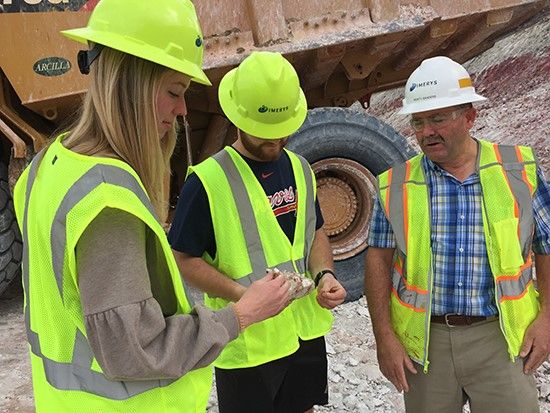 Students Emily McCord and Michael Veal inspect kaolin at a construction site with Monty Sanders