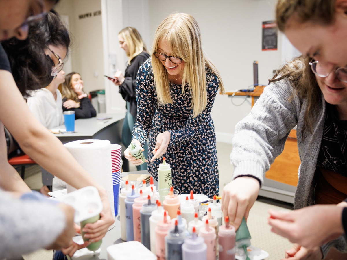 Professor Lindsay Jones lines up to get glaze for a bowl painting event.