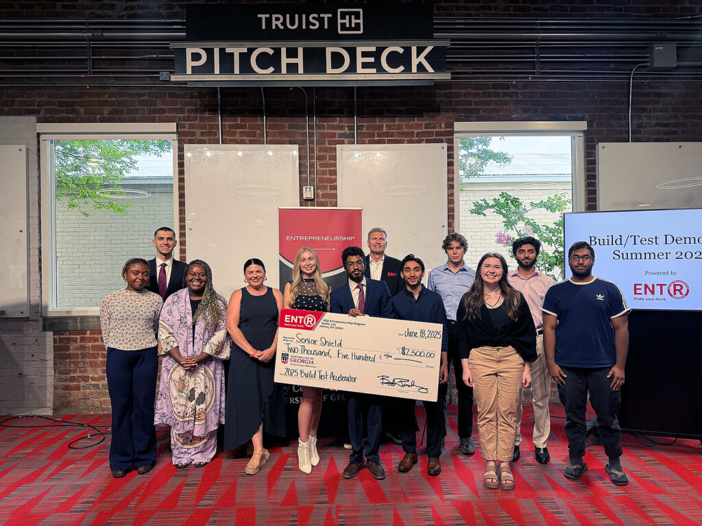 Students and judges at the UGA Entrepreneurship 2025 Build/Test Accelerator Pitch Contest stand in front of the Truist pitch deck.