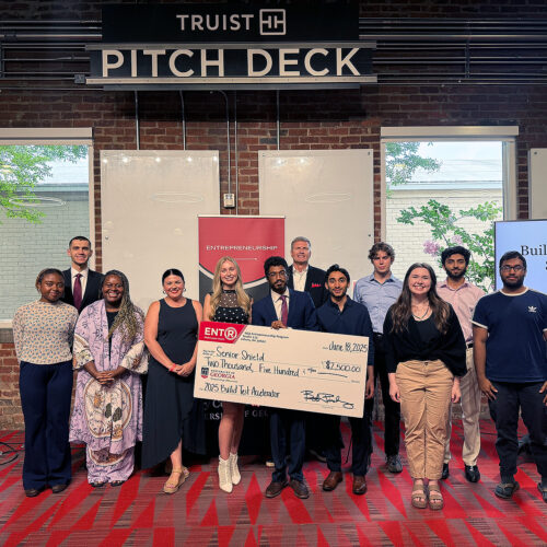 Students and judges at the UGA Entrepreneurship 2025 Build/Test Accelerator Pitch Contest stand in front of the Truist pitch deck.