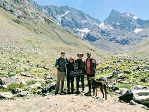 Four hikers stand in front of a glacier in Chile.