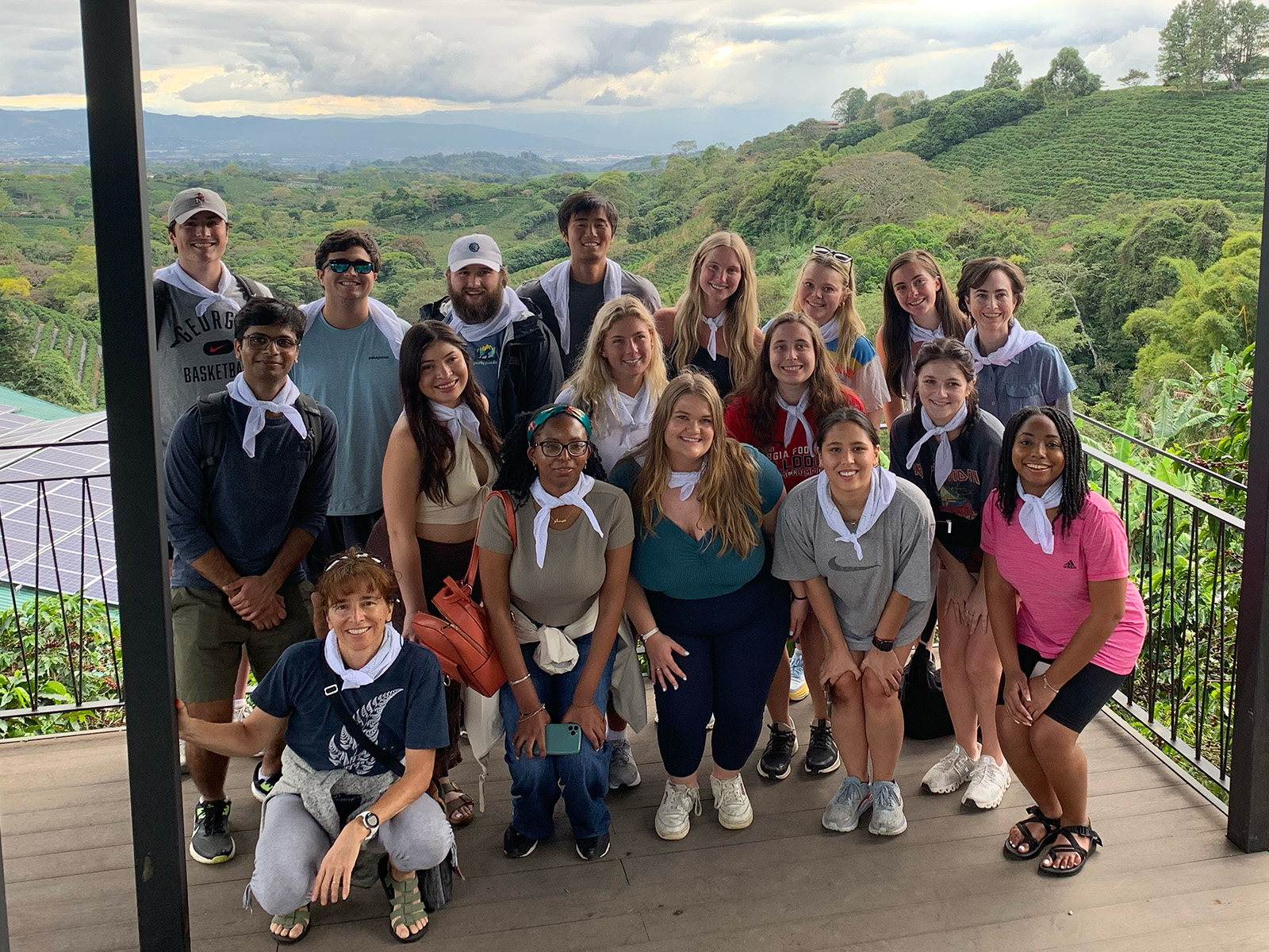 Group photo of 16 Terry students standing in front green hills in Costa Rica