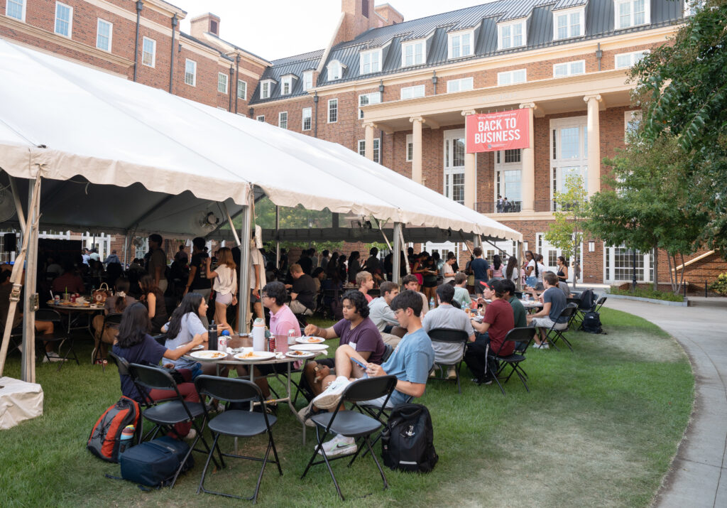 Students spill out a tent on CocaCola plaza at the Business Learning Community Terry College Welcome Back Block Party