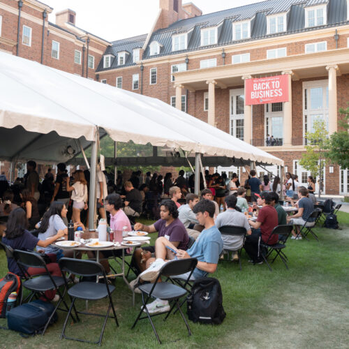 Students spill out a tent on CocaCola plaza at the Business Learning Community Terry College Welcome Back Block Party
